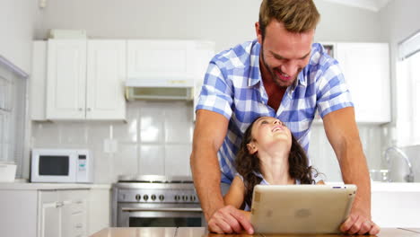 Daughter-and-father-laughing-in-front-of-a-tablet