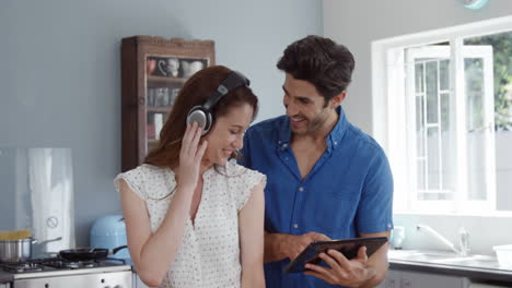 Cute-couple-using-tablet-while-listening-to-music