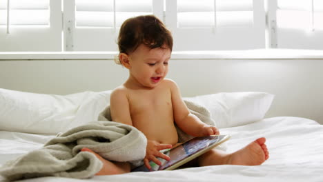 A-baby-boy-is-looking-his-tablet-on-the-bed