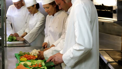 Chef-chopping-vegetables-on-green-board