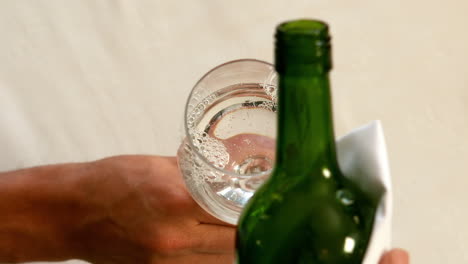 Waiter-pouring-a-bottle-of-white-wine