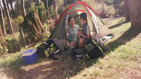 Happy-couple-having-cup-of-coffee-in-tent