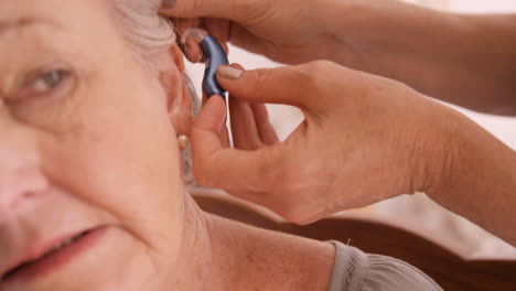 Ärztin-Setzt-Hörgerät-Ins-Ohr-Einer-älteren-Frau-Ein