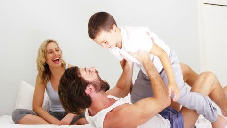 Happy-family-playing-together-on-a-bed