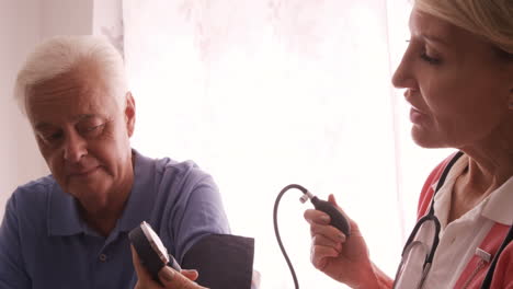 Ärztin-überprüft-Den-Blutdruck-Eines-älteren-Mannes