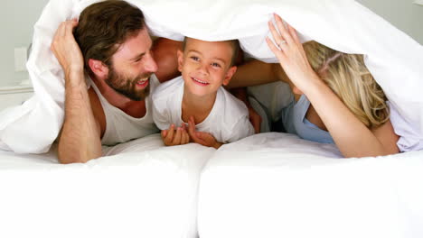 Happy-family-playing-together-on-a-bed