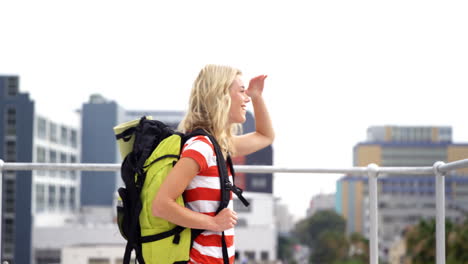 Smiling-hipster-with-backpack-visiting-a-city