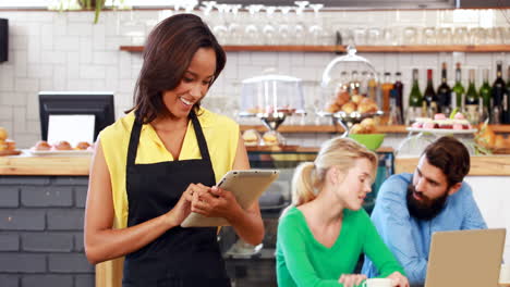 Smiling-waitress-holding-a-tablet