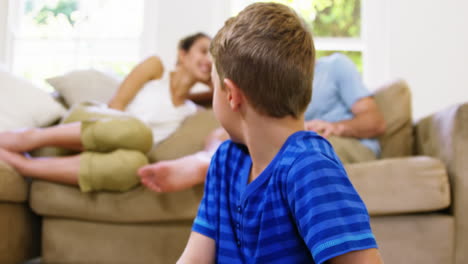 Kid-playing-in-front-of-the-camera-with-parents-behind