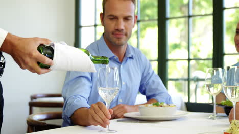 Handsome-waiter-pouring-wine-in-a-client-glass