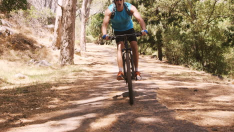 Man-biking-through-a-forest-