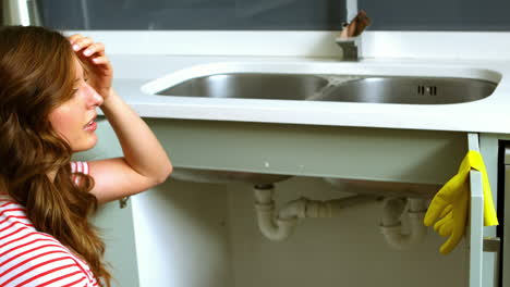 Woman-kneeing-in-front-of-sink
