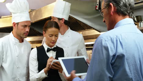 Man-giving-instructions-to-the-chefs