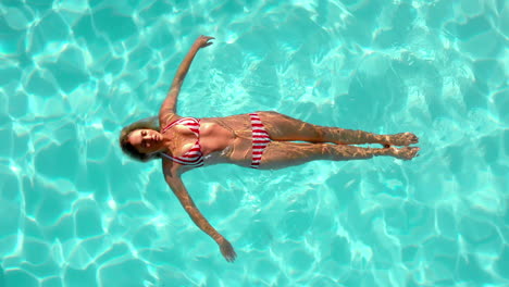 Woman-floating-in-the-swimming-pool-in-cinemagraph