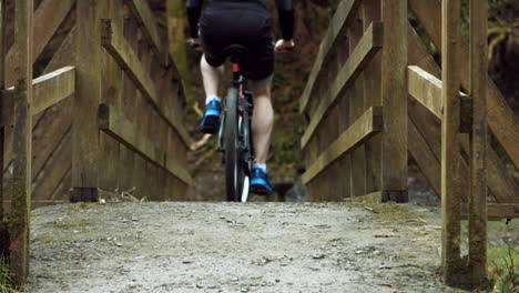 Hombre-Montando-Su-Bicicleta-Sobre-El-Puente