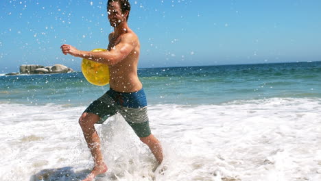 Man-getting-out-of-water-with-beach-ball