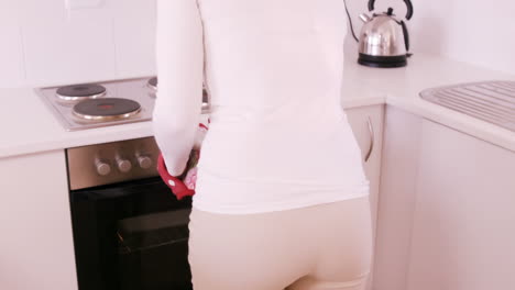 Blonde-woman-getting-dish-out-oven