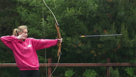 Blonde-woman-shooting-bow-and-arrow-in-cinemagraph