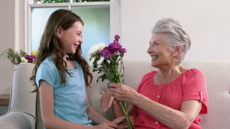 Enkelin-Bietet-Ihrer-Großmutter-Blumen-An
