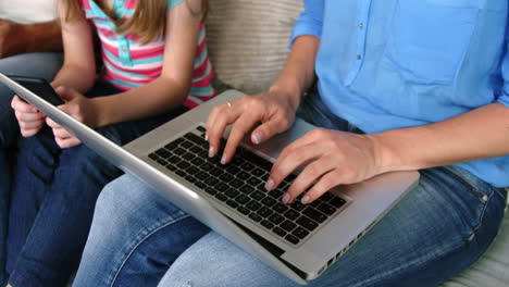 Eine-Mutter-Und-Ihre-Tochter-Ruhen-Sich-Auf-Dem-Sofa-Aus-Und-Benutzen-Einen-Laptop