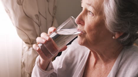 Kranke-ältere-Frau-Nimmt-Tabletten-Mit-Wasser