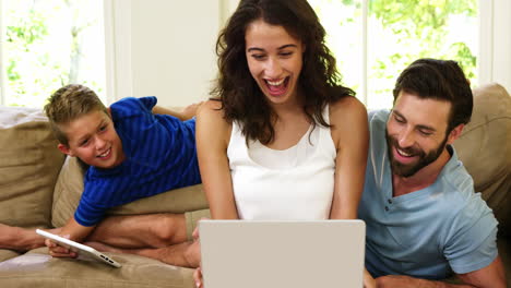 Smiling-family-looking-at-their-laptop