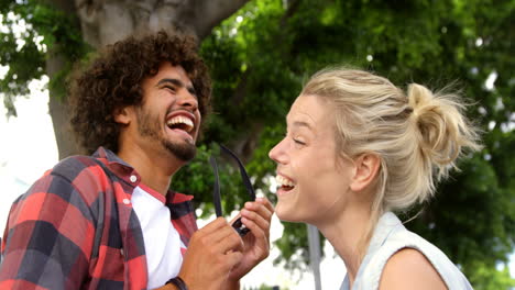 Friends-laughing-while-removing-sunglasses