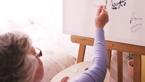 Senior-woman-painting-on-canvas
