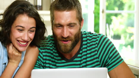 Couple-smiling-and-laughing-in-front-of-a-laptop