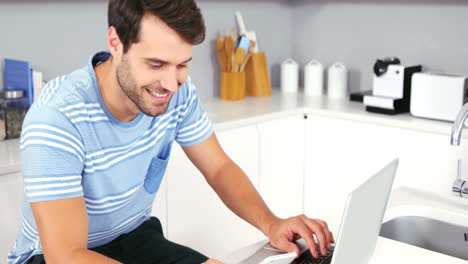 Handsome-man-using-laptop-and-smartphone