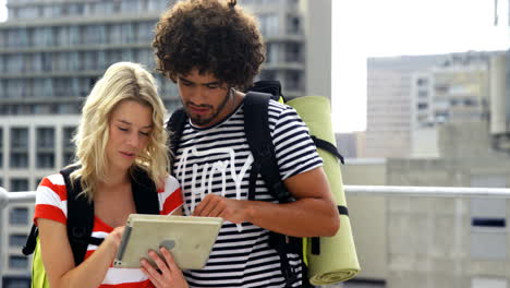 Couple-of-two-hipsters-turning-towards-with-tablet-computer