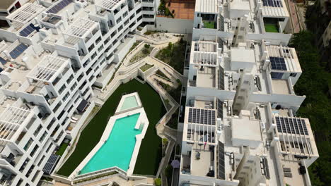 Weiße-Apartmentgebäude-Mit-Privatem-Poolbereich-In-Der-Stadt-Estepona,-Luftaufnahme-Vom-Gipfel