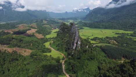 Aerial-drone-image-of-the-Nam-Xay-Viewpoint,-showcasing-its-stunning-view-of-rice-fields-and-mountains-near-Vang-Vieng-in-Laos