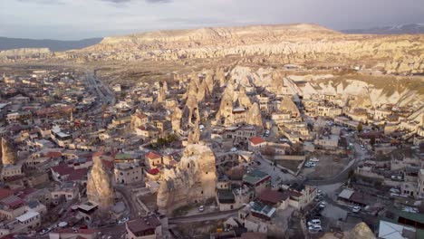 Aerial-Drone-View-of-Goreme-Turkey,-Edge-of-City-Limits:-Scenic-Town-Nestled-in-the-Heart-of-Cappadocia's-Unique-Rock-Formations---Fairy-Chimney-House:-Downtown-Göreme,-Nevşehir-Türkiye