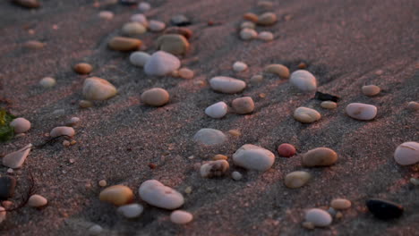Close-Up-Pebblles-Rest-on-Beach-at-Sunset