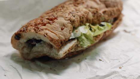 Sub-Sandwich-Moving-Close-Up-Showing-Toasted-Bread-with-Cheese-with-Lettuce-Cucumber-Steak