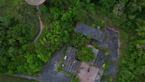 Overhead-view-of-Old-abandoned-satellite-and-old-abondoned-building-in-front-of-a-beach