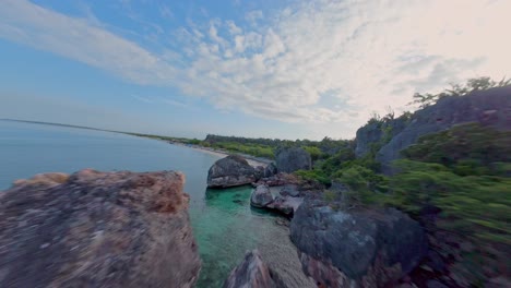 Vuelo-Fpv-Entre-Rocas-De-La-Costa-Y-Playa-De-Arena-En-La-Cueva-Durante-El-Atardecer