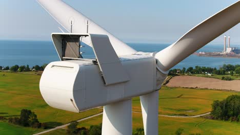 Gondel-Einer-Windturbine-Mit-Meer-Und-Ackerland-Im-Hintergrund