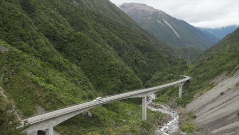 Mini-tour-bus-riving-over-Otira-Viaduct-bridge-in-Arthurs-Pass-New-Zealand