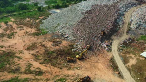 Birds-eye-view-flyover-capturing-abandoned-sanitary-landfill-with-large-piles-of-unsorted-solid-wastes-in-the-illegal-dump-site,-concept-of-environmental-sustainability,-global-warming,-climate-change