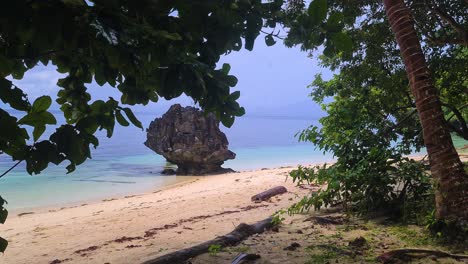 Empty-Wild-Beach-on-Tropical-Island,-Trees,-Sand-and-Rock-in-Sea