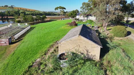 Antena-Sobre-Un-Antiguo-Edificio-De-Almacenamiento-En-Un-Viñedo-En-El-Valle-De-Yarra-Cerca-De-Yarra-Glen-En-Victoria,-Australia