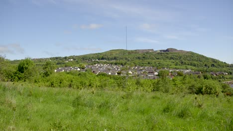 Left-to-right-camera-move-produced-in-25fps-slow-motion-showing-the-Black-Mountain-AKA-Divis-Mountain-in-West-Belfast,-Northern-Ireland-on-a-sunny-day