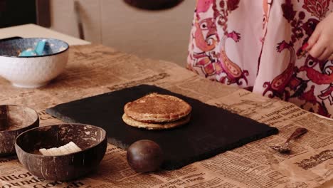 Cook-stacking-pancakes-on-a-plate-preparing-breakfast