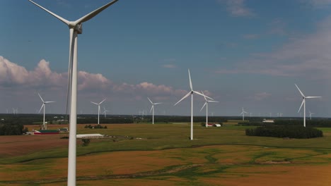 Wind-Turbines-Spinning-in-the-Wind-with-a-Scenic-Aerial-Shot-Over-Farmland