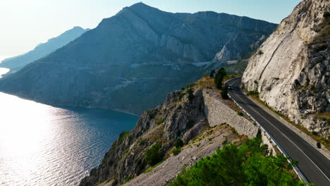 Cars-on-route-D8-in-the-mountains-of-the-Makarska-riviera,-Croatia---Aerial-view