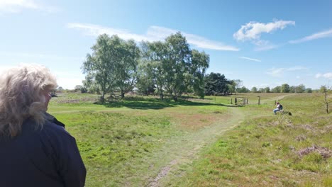 Woman-walker-observing-along-countryside-sanderling-trail-path-Suffolk