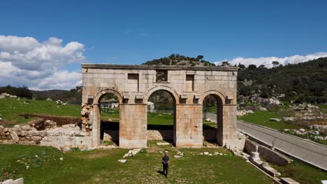 Solo-Tourist-Man-Walks-Thru-Arched-Gates-to-Ancient-Patara-on-the-Turkish-coast