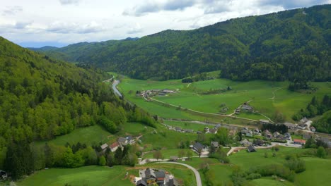 Beautiful-green-valley,-village-road-network,-mountains-above,-aerial